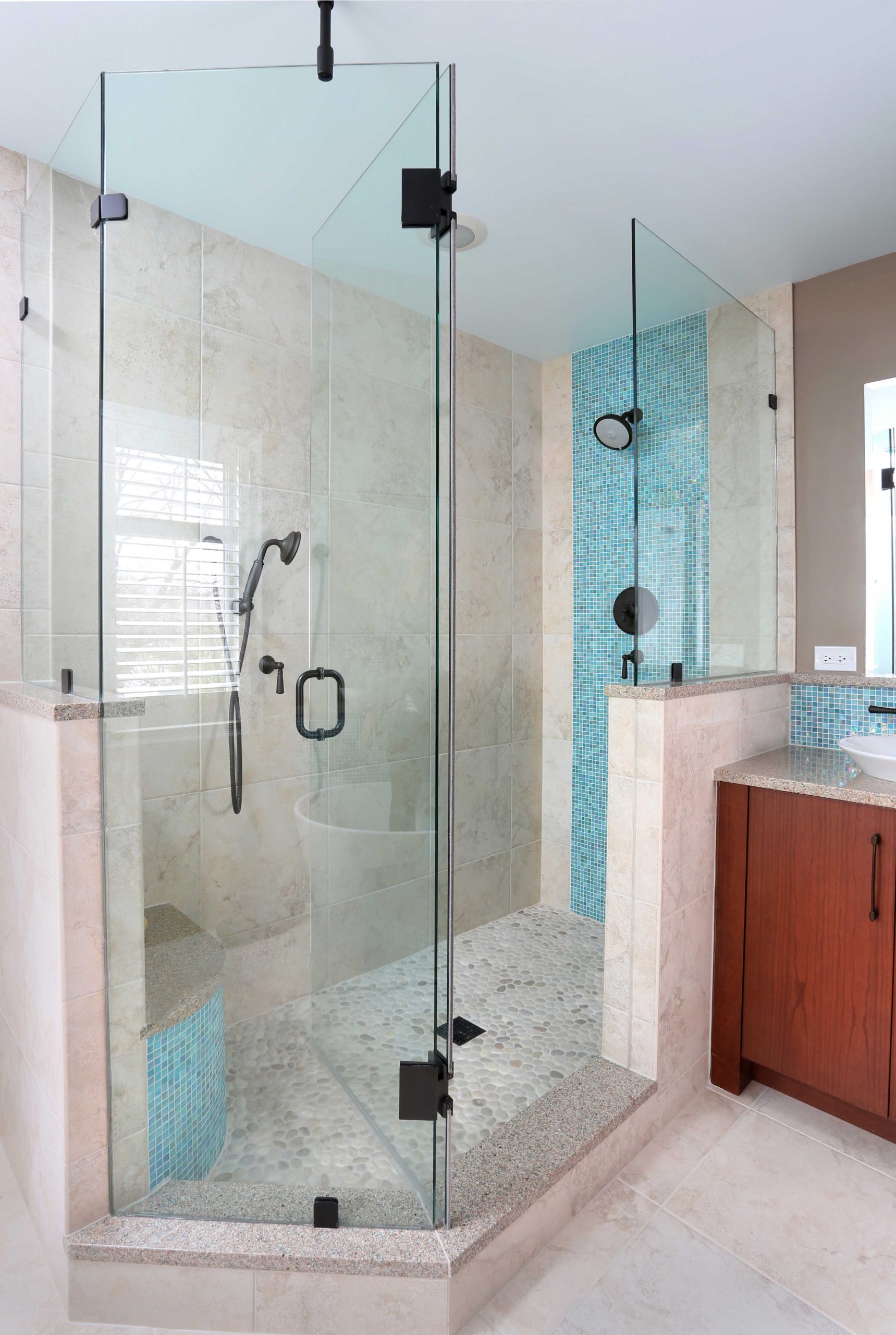 Bathroom shower with pebble flooring and vertical blue accent tile