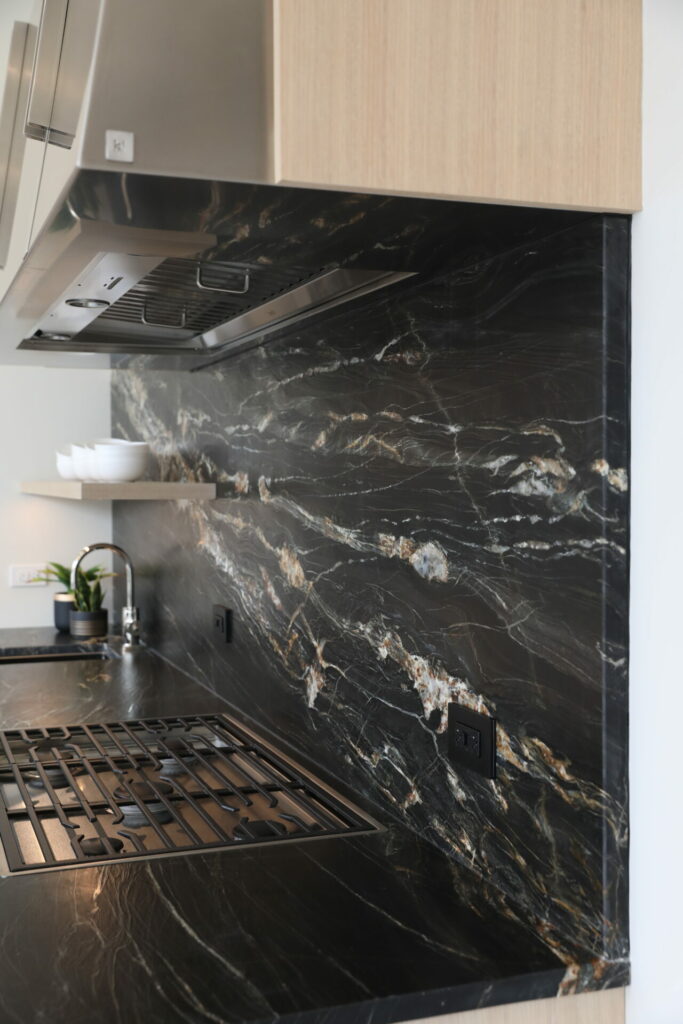 modern kitchen with dark countertops in leathered finish