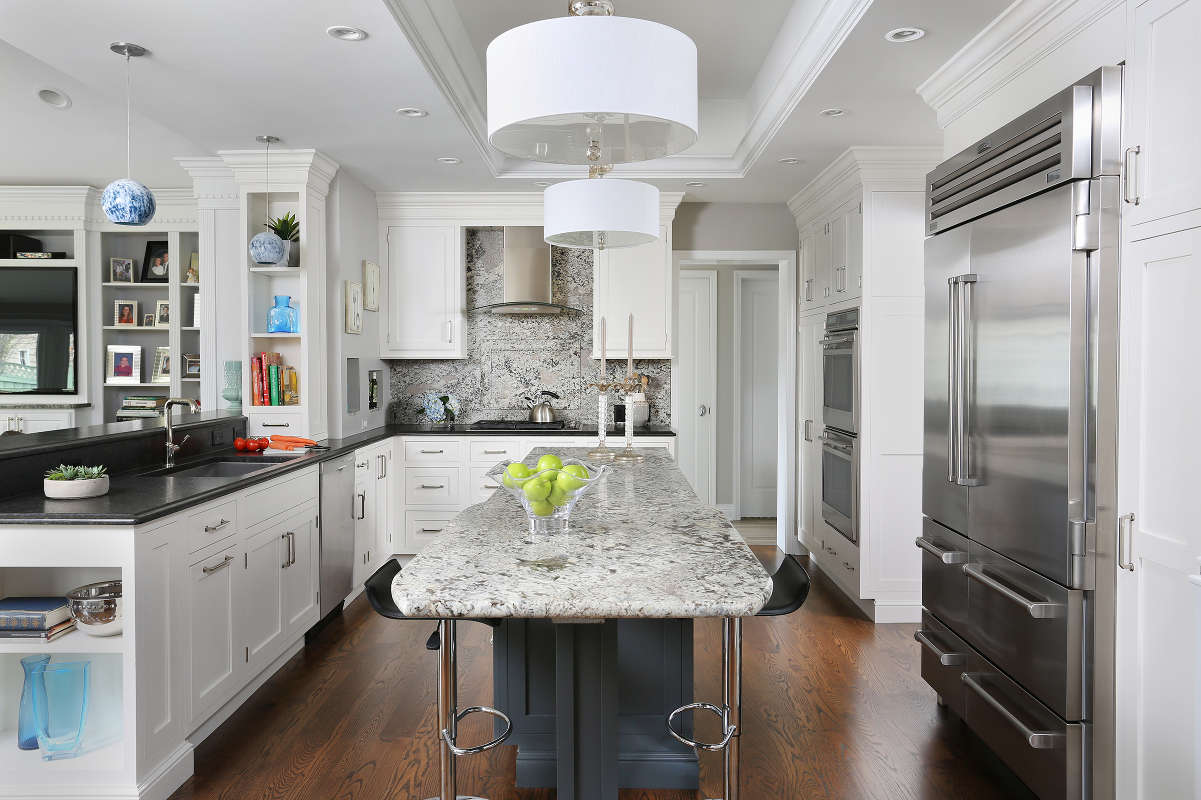 White kitchen with slab backsplash and dark island