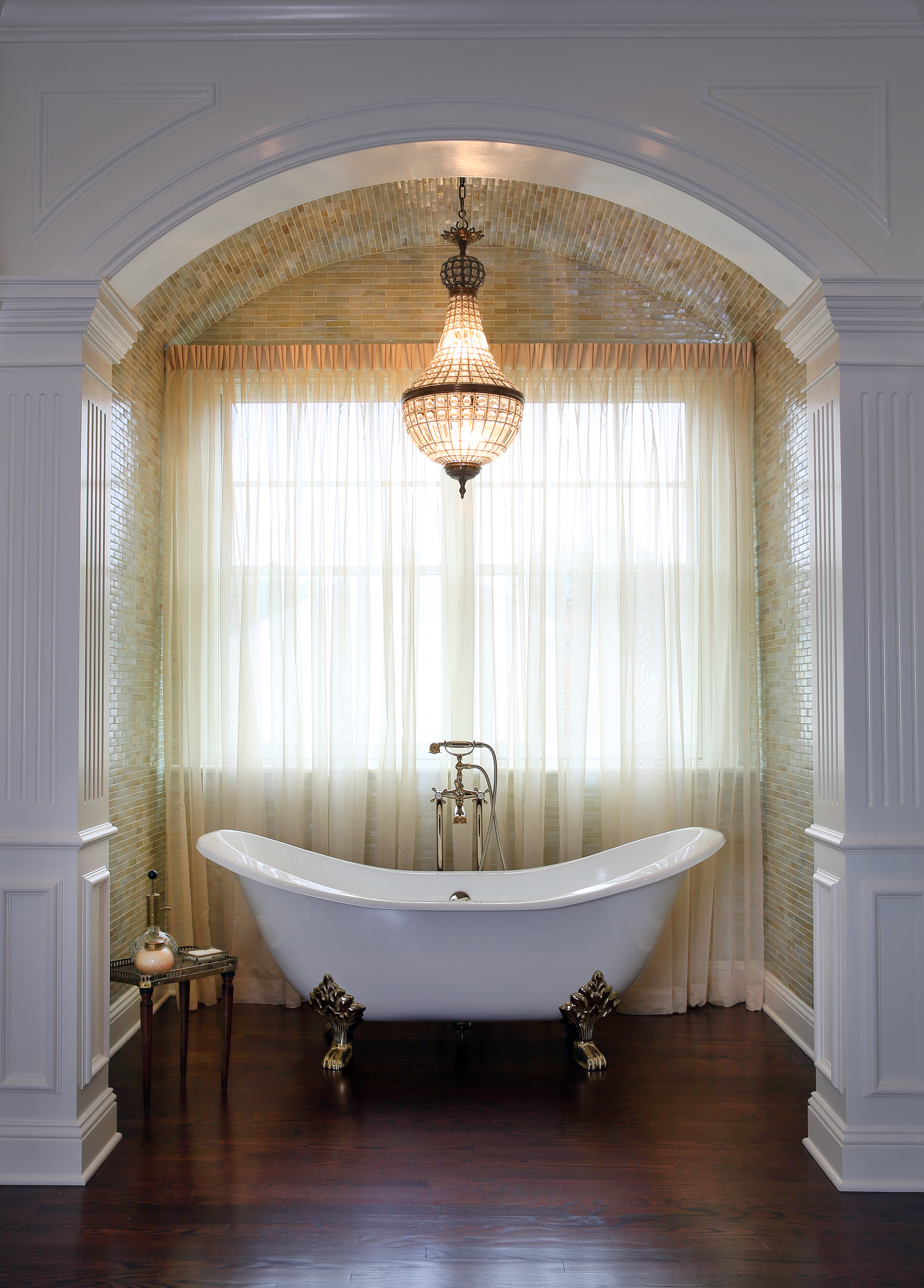 Clawfoot tub with chandelier in tiled barrel ceiling