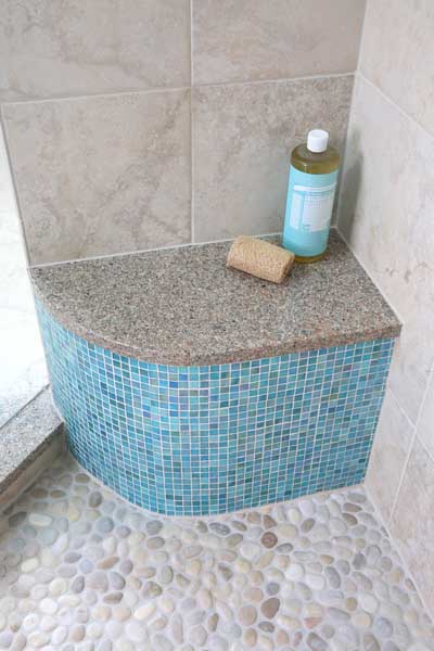 Small bench in a shower with colorful blue tile