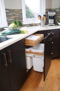 Trash can integrated into a kitchen cabinet