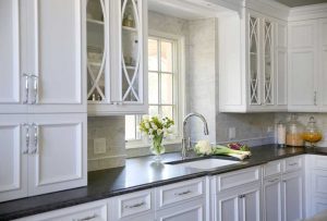 White kitchen cabinets with sink in front of a window