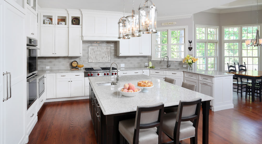 u-shaped white traditional kitchen with dark stained eat-in island