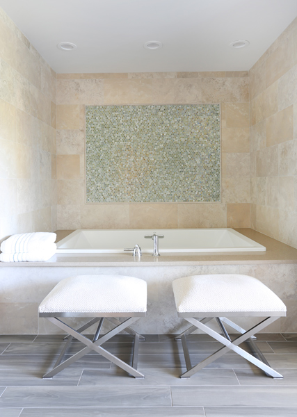 Large bathtub with decorative accents on the back wall