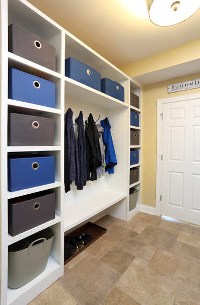 Shelves for baskets surround a spot for hooks and bench for comfortably putting on your shoes