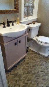 vanity with curved front sink and herringbone tile pattern