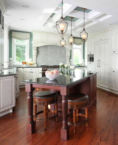 off white painted kitchen with stained island and coffered ceiling