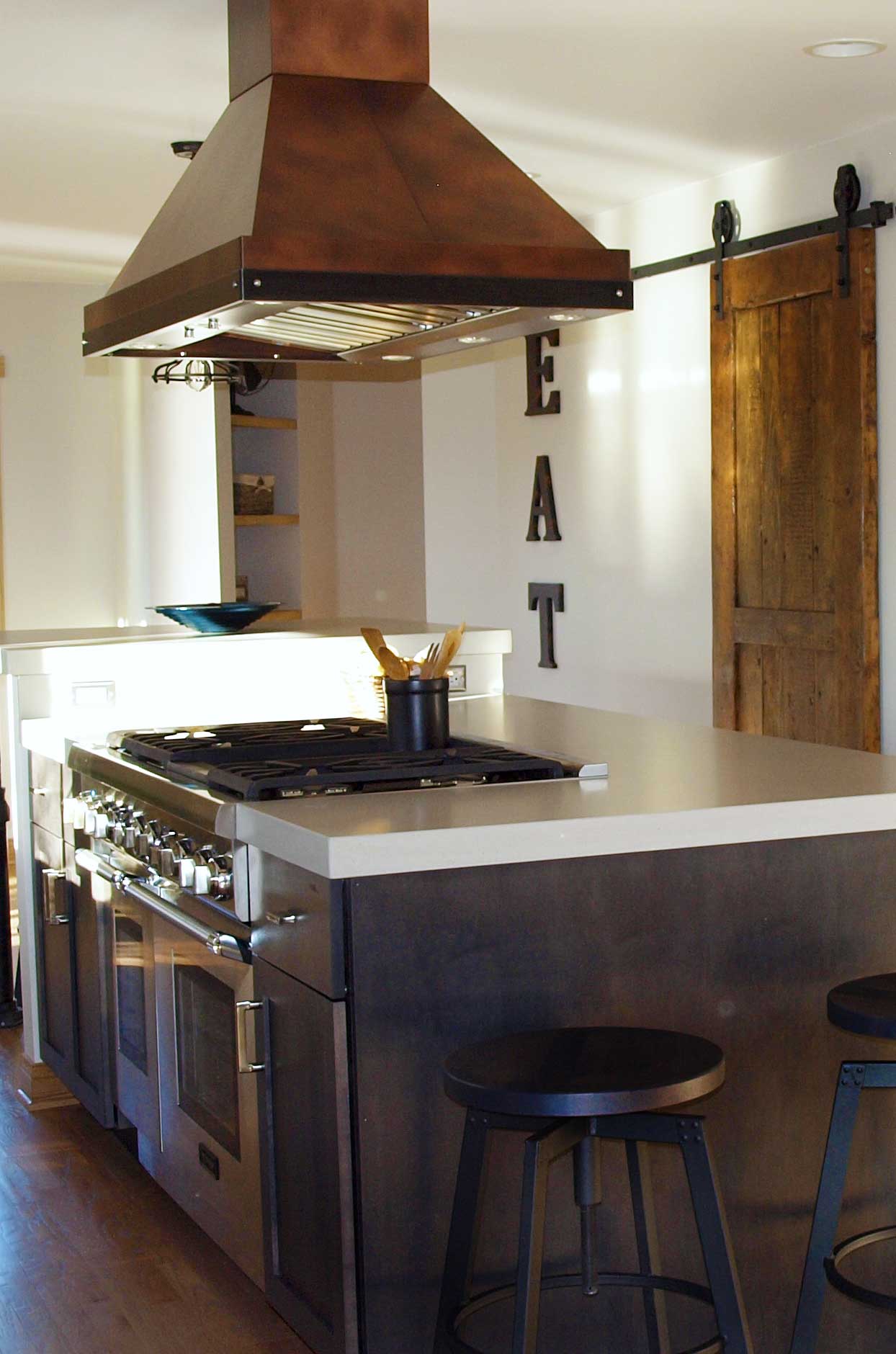 copper range hood above island