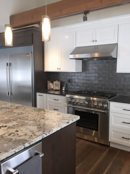 White kitchen cabinetry with stainless steel hood and exposed beams