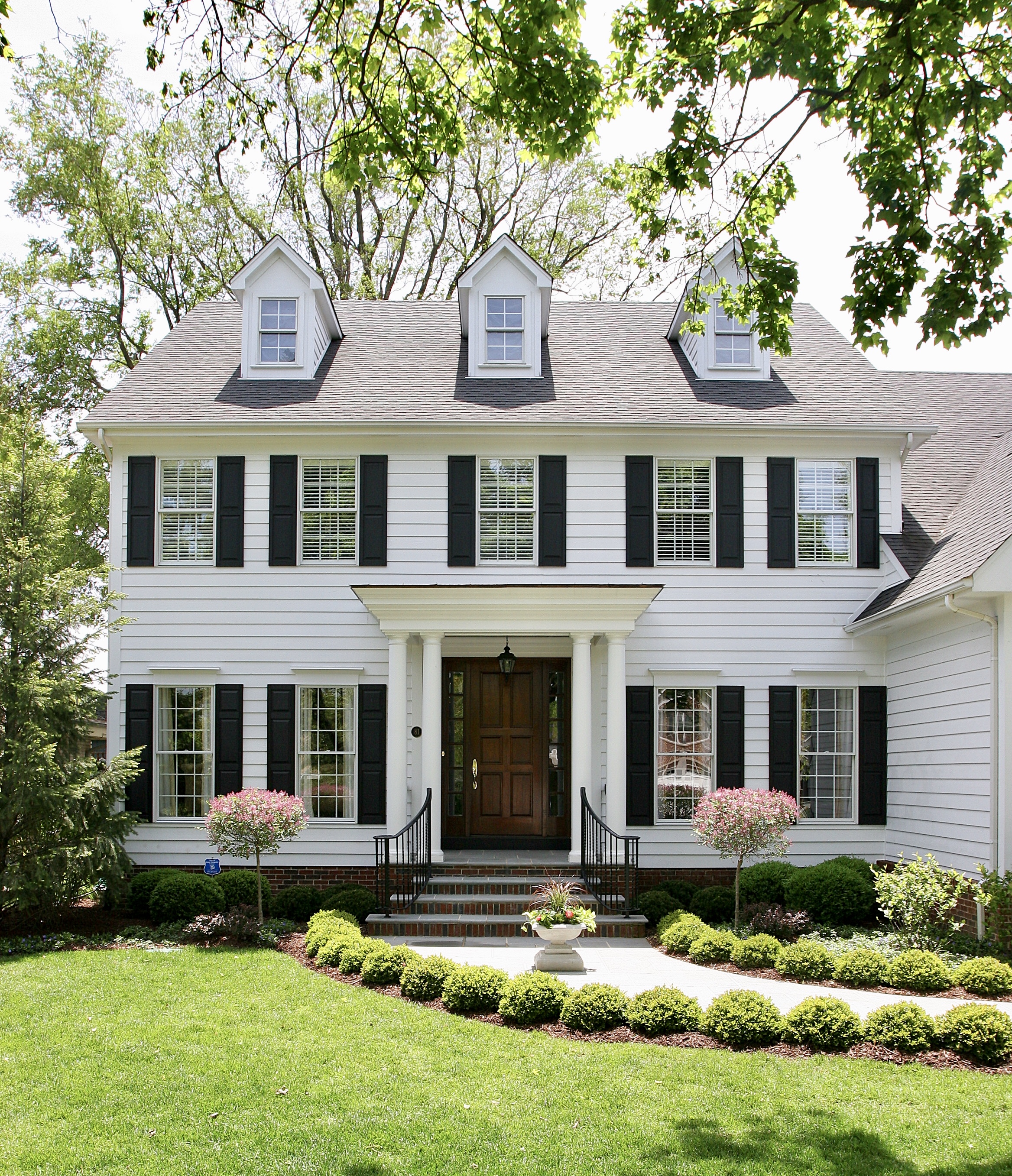 White colonial style house with covered front porch