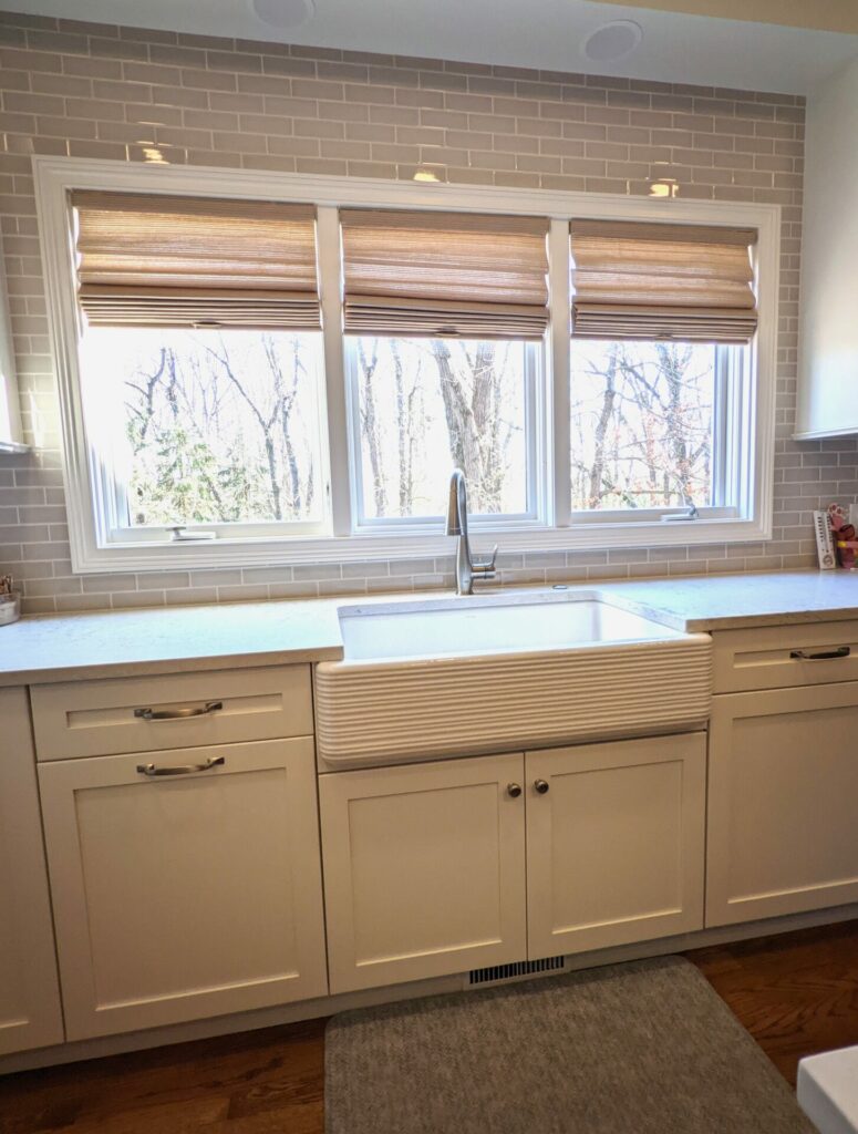 white kitchen with textured apron front sink and warm taupe backsplash