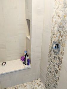 Shower with bench, river rock tile, built in shelf for storage