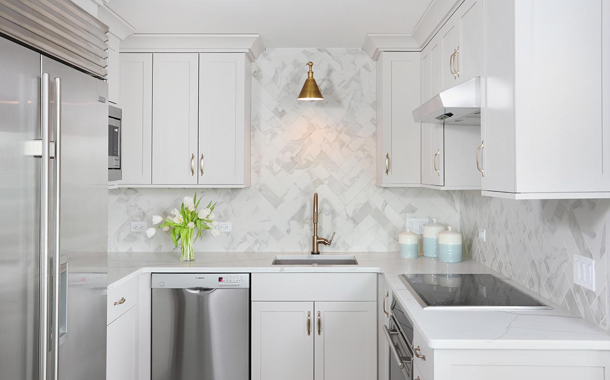 Light Gray cabinets, subzero fridge, stainless appliances, marble-look backsplash