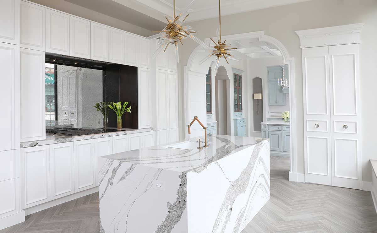 White kitchen cabinets with waterfall wrapped island