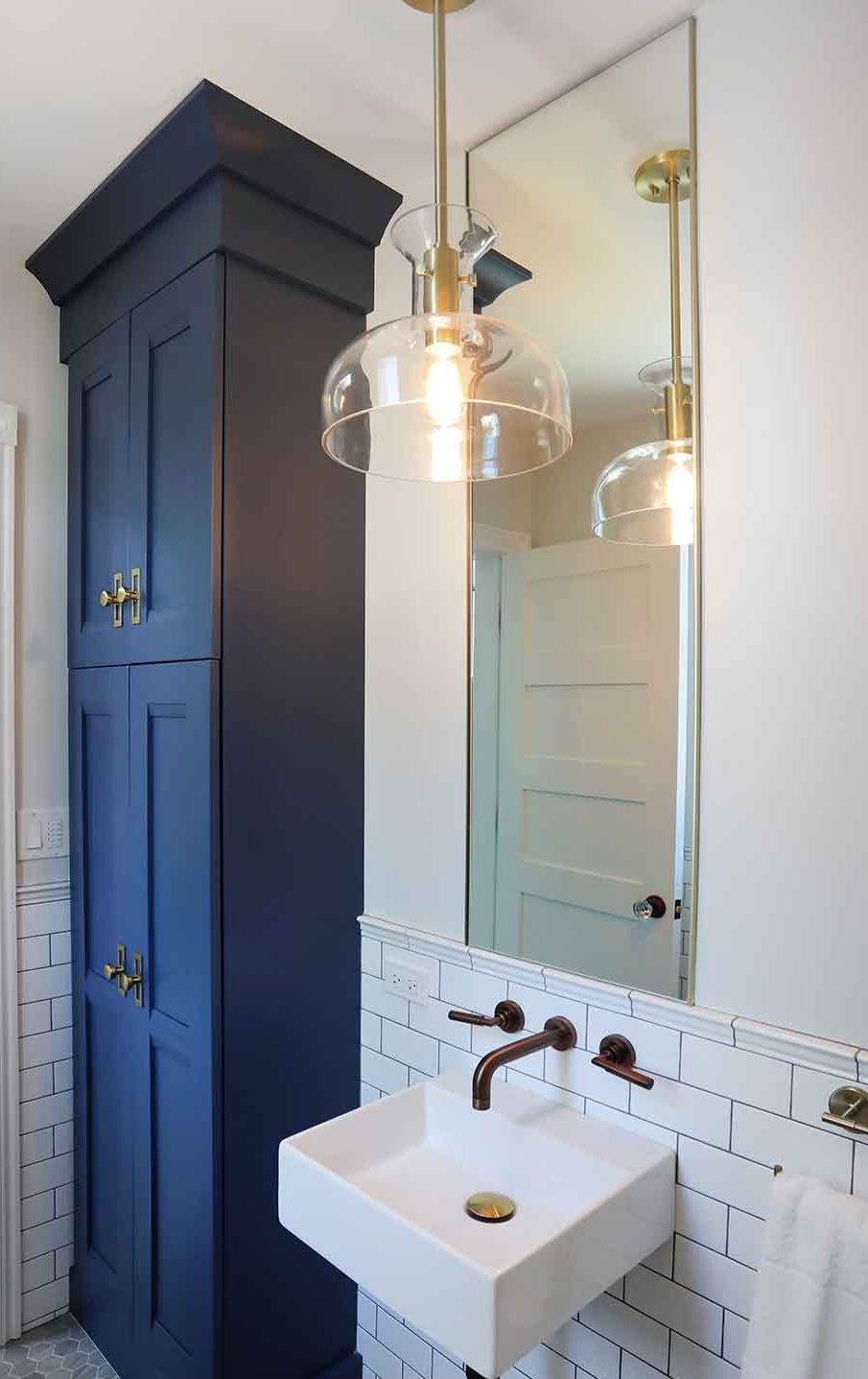 Powder room, tall ble cabinetry, gold light pendant and brass fixtures