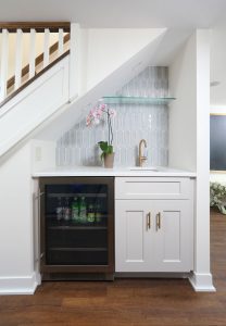 Basement wet bar, beverage fridge, faucet, sink open glass shelving, storage cabinet