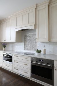 white cabinetry, patterned tile, subway tile backsplash