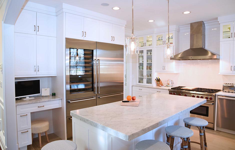 White painted kitchen cabinets in a shaker door style with island and carrera marble countertops