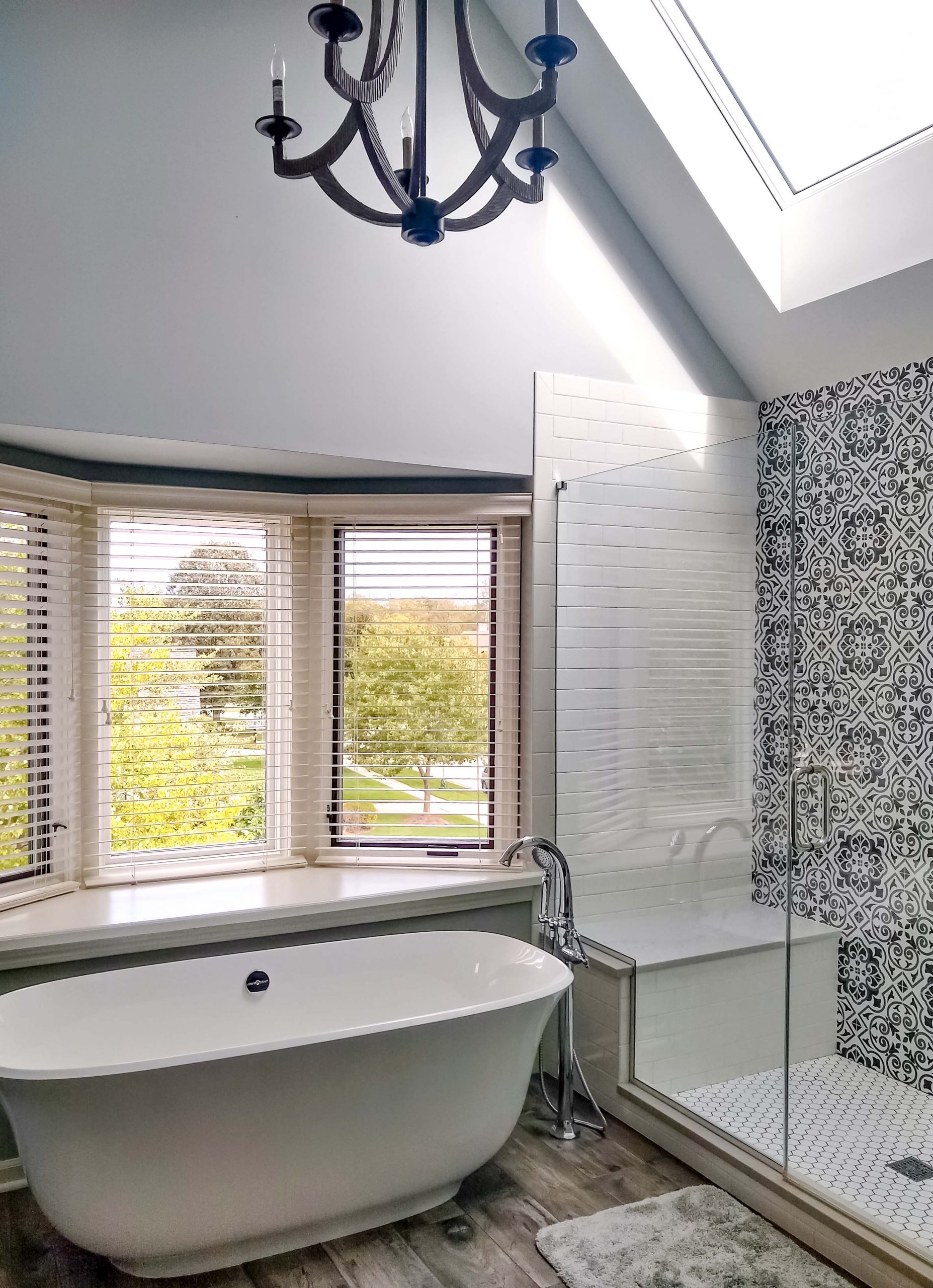 Primary bathroom with bay window and skylight for natural light