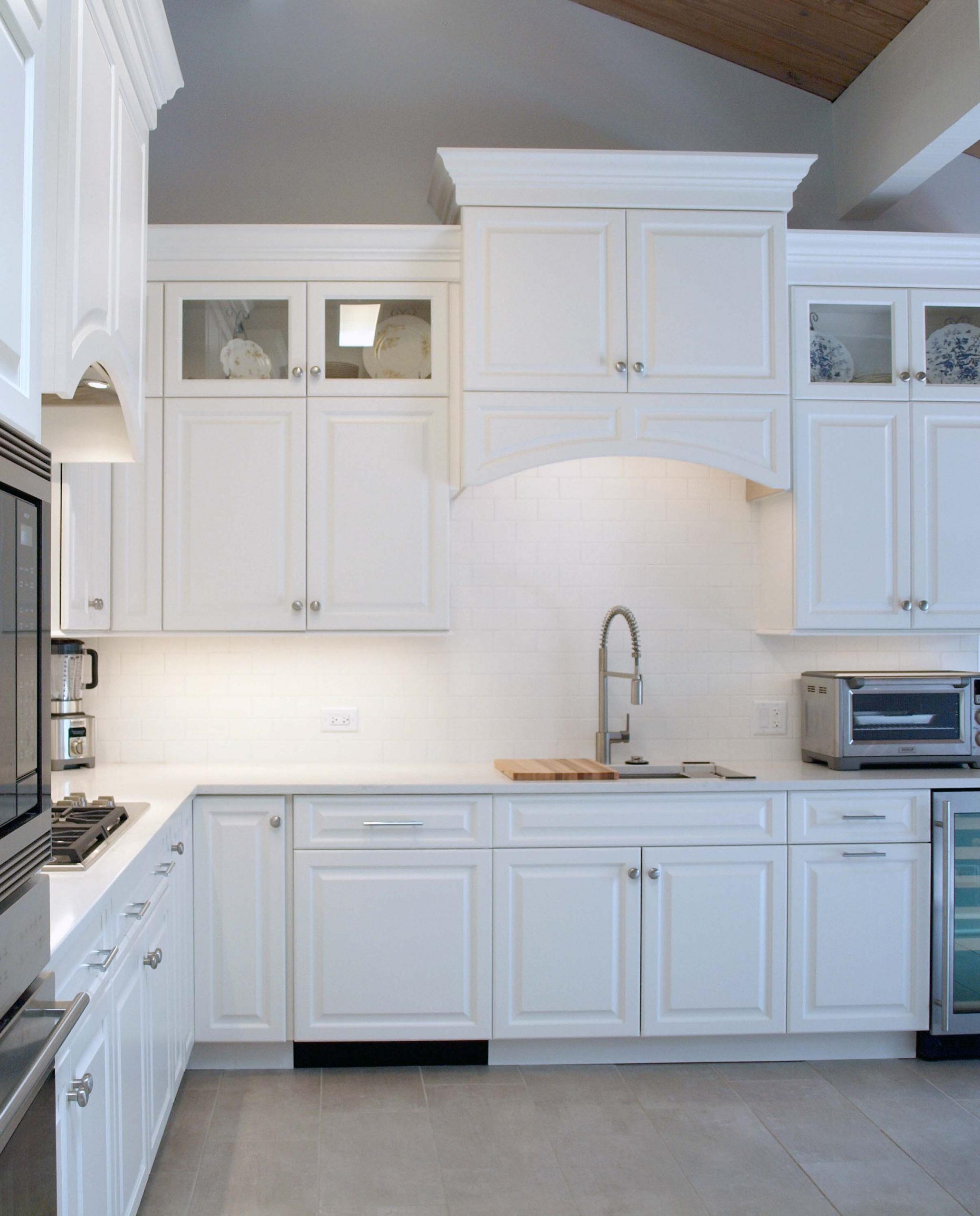 White kitchen with wood paneled vaulted ceiling