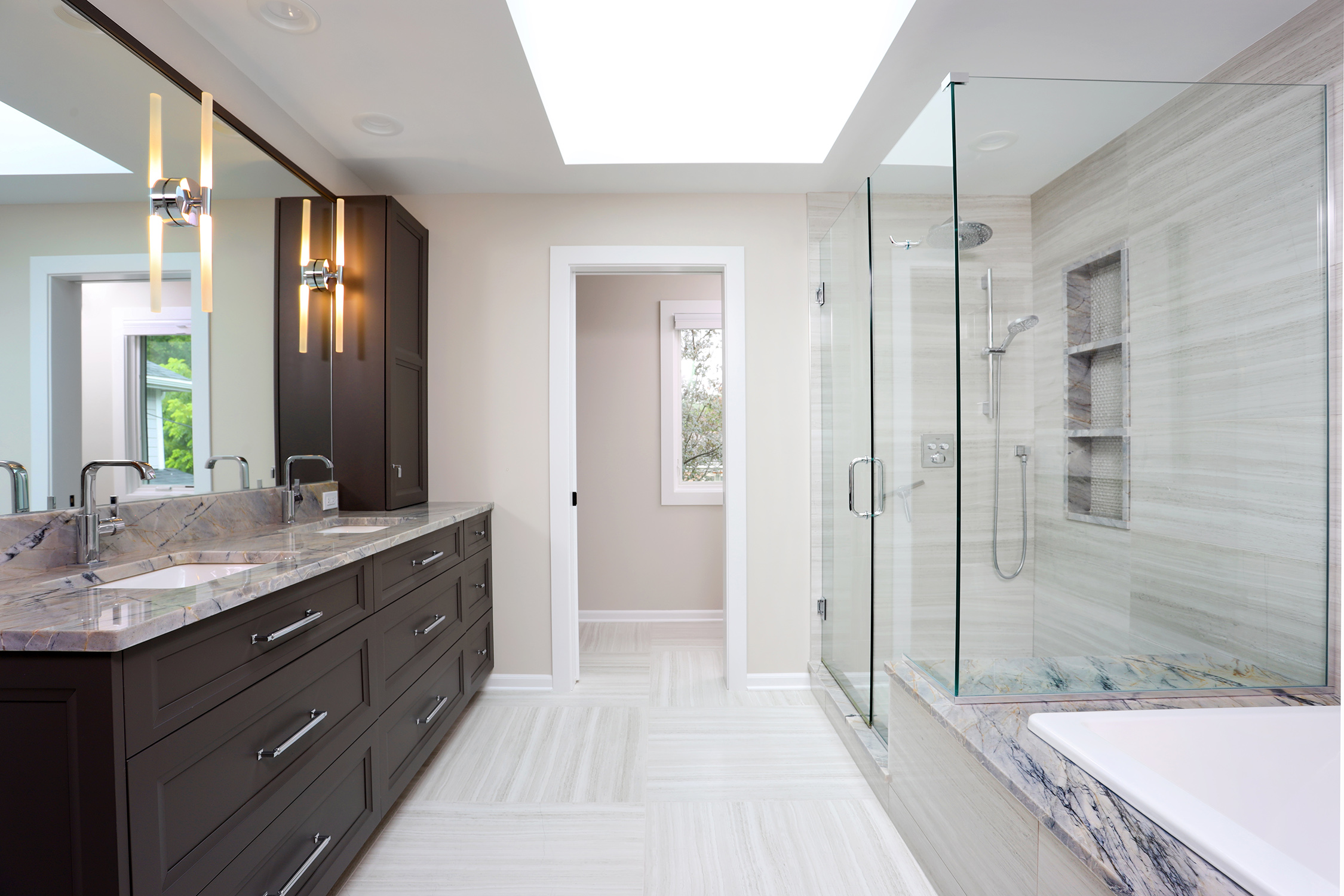 Bathroom with stained vanity, glass shower enclosure, and bathtub