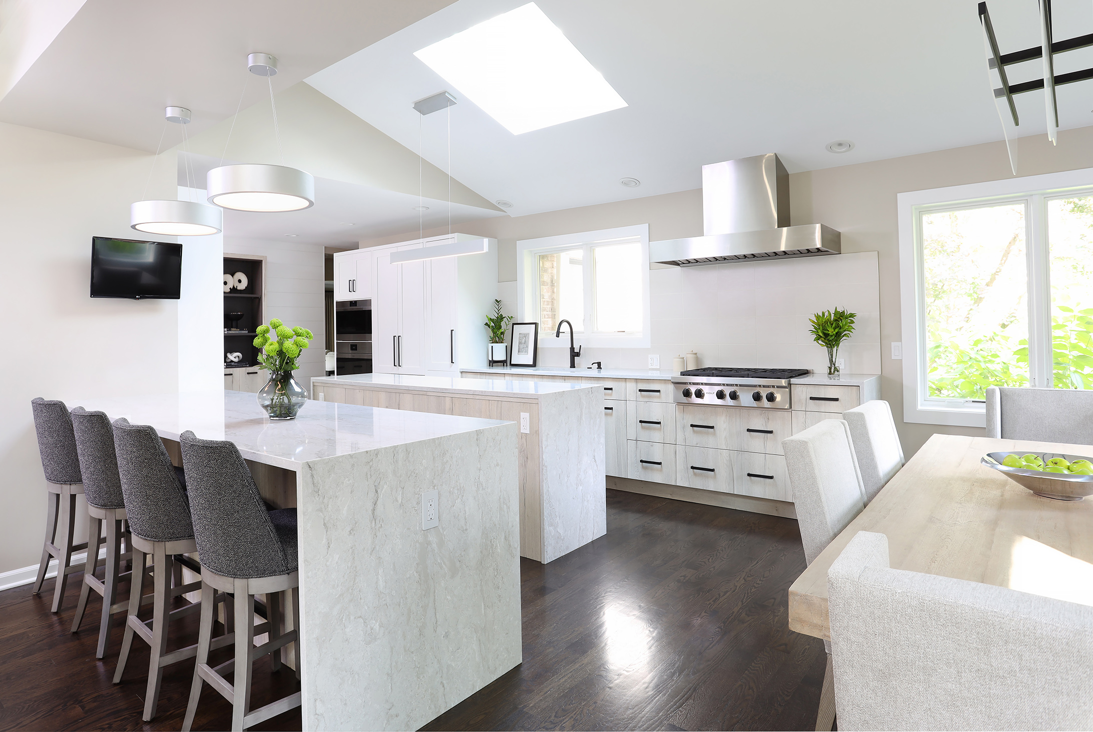 Modern light colored kitchen with waterfall countertops