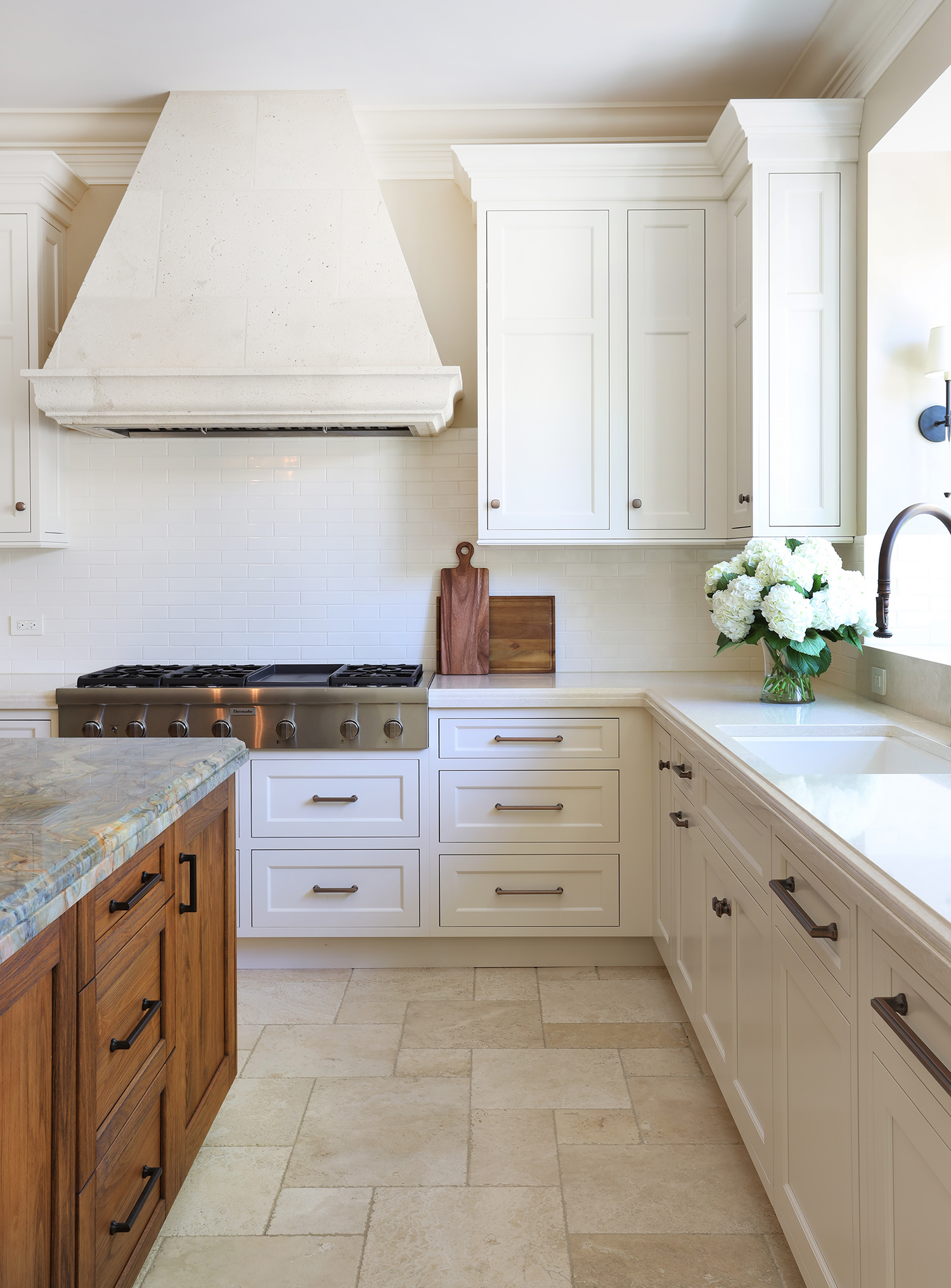 Traditional kitchen with white painted perimeter cabinets and stained island