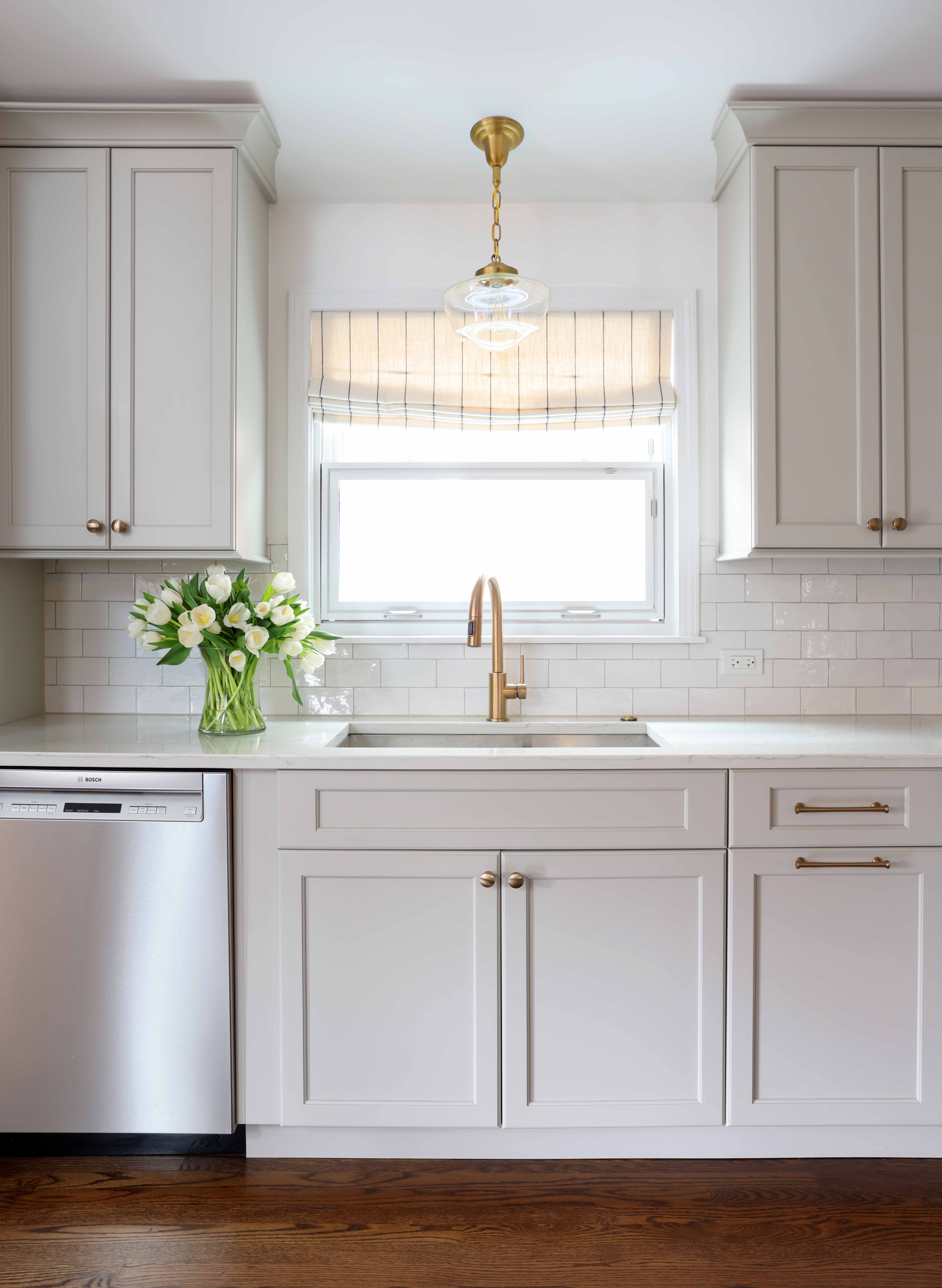 Soft gray kitchen with sink and stainless dishwasher