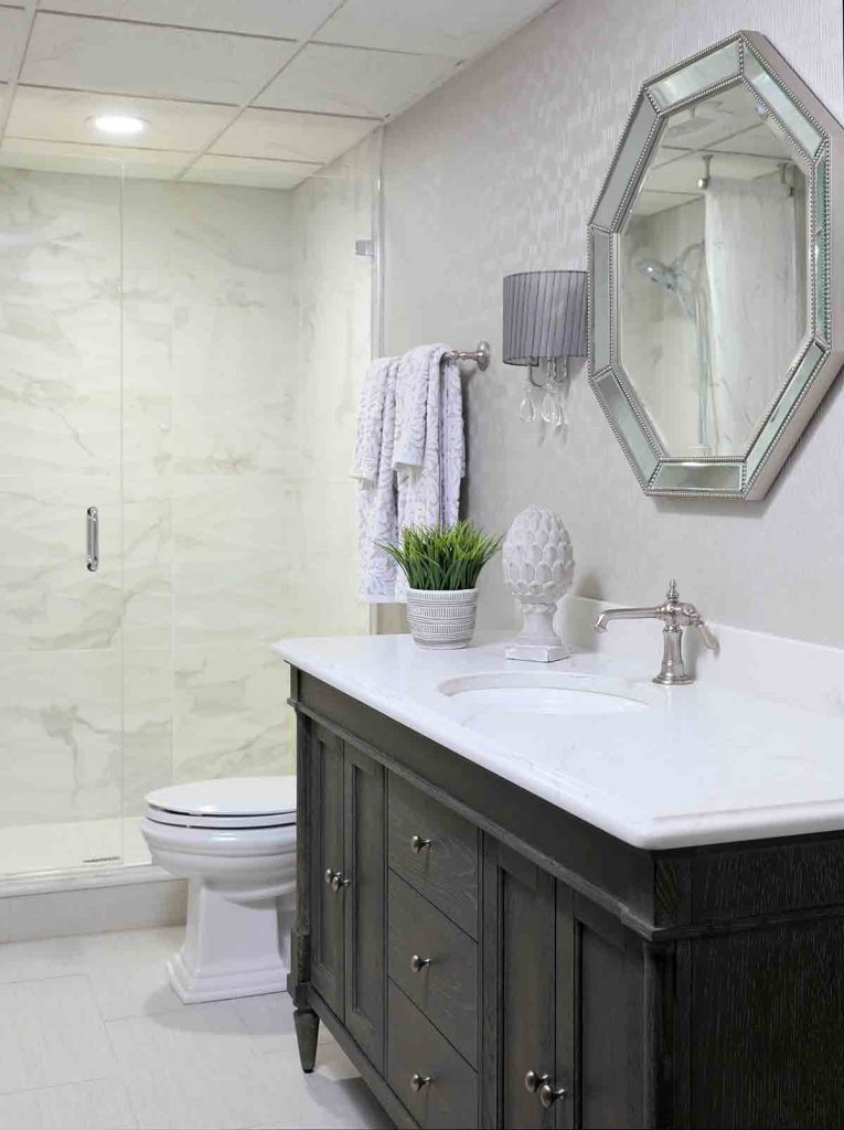 basement bathroom with dark stained vanity and shower