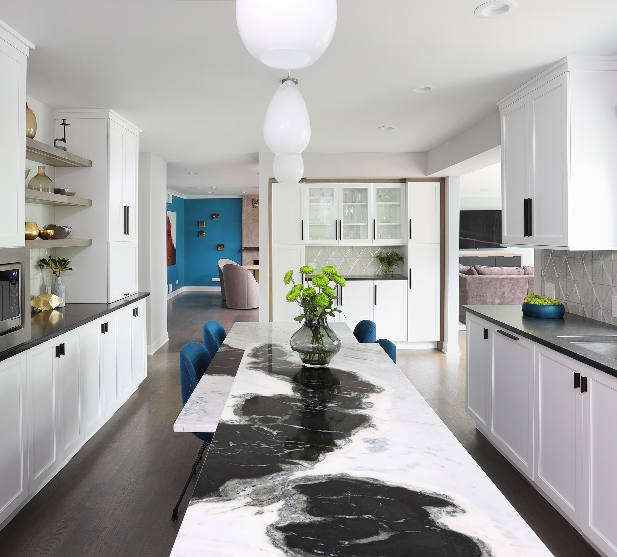 White kitchen with two tier island with natural stone