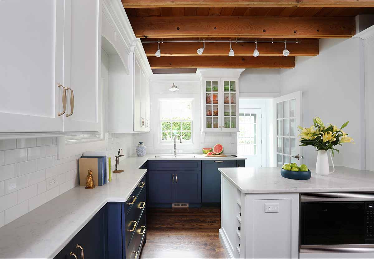 blue cabinets and white island with wood beam ceiling