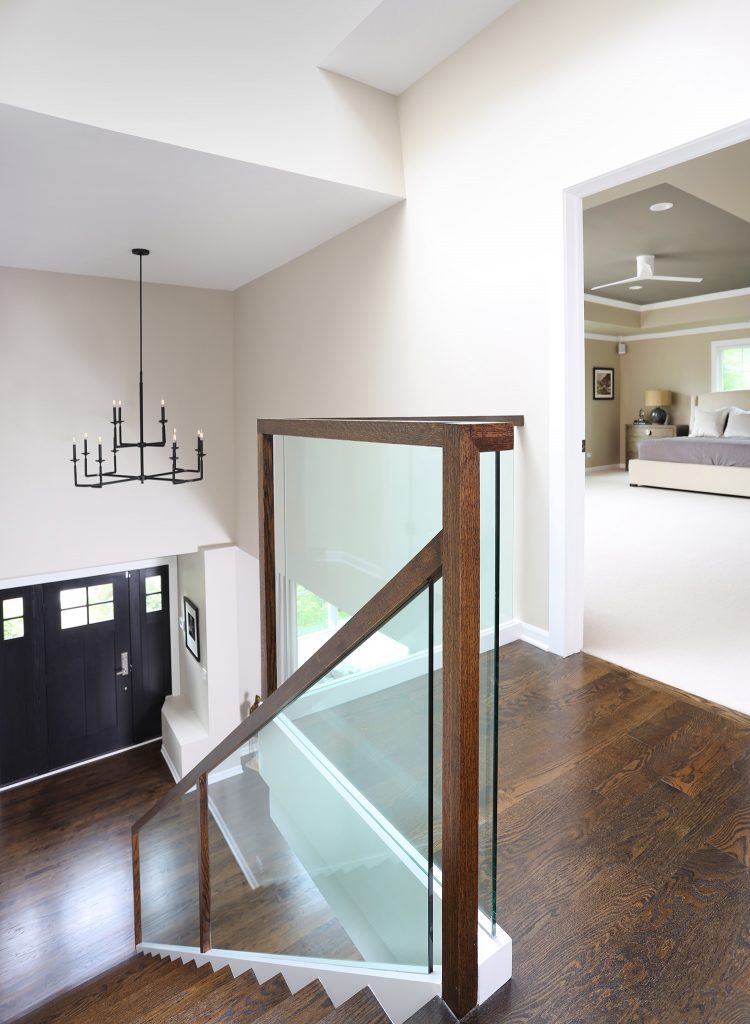 modern glass and wood staircase overlooking foyer