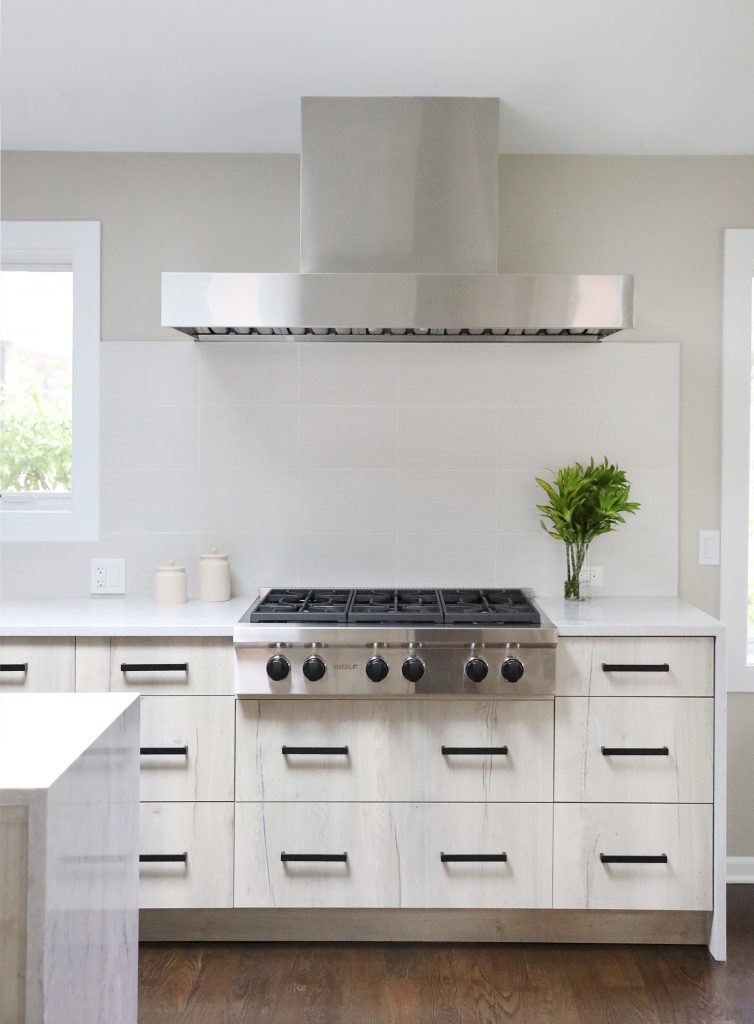 modern kitchen, waterfall edge island, large hood range, tile to ceiling