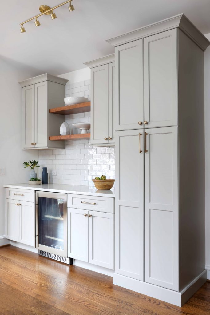 soft white cabinetry with open wooden shelving above beverage center in kitchen