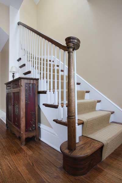 carpeted staircase with wood posts