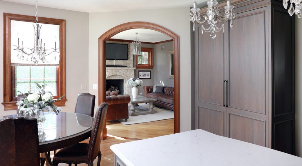 Traditional kitchen dining area with arched doorway and hardwood flooring