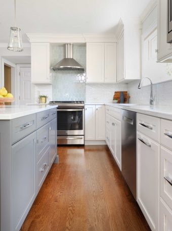 White and gray kitchen cabinets with hardwood floors and stainless appliances