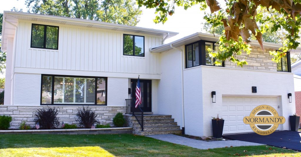 white split level house with black window trim is modernized 