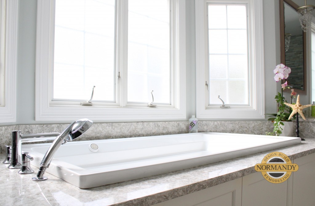 Bathtub with a tub deck under windows