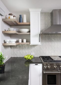 Floating shelves in an L shape in the kitchen with textured white wall tile