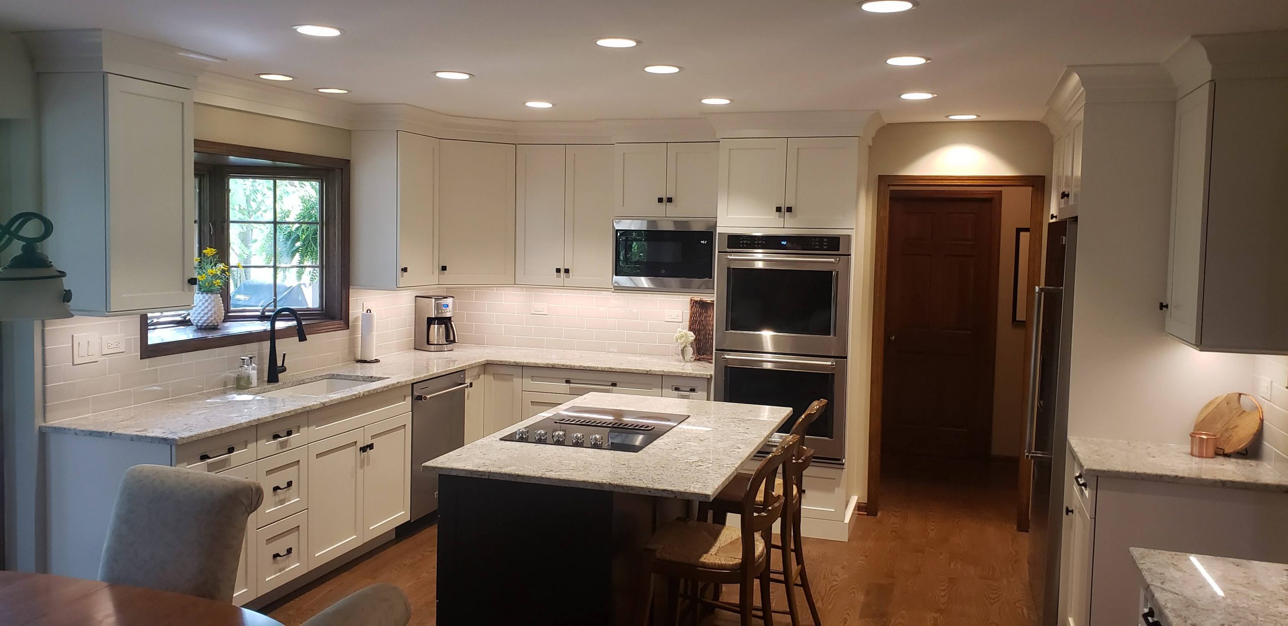 White kitchen cabinets with cooktop in the island