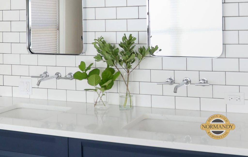 wall-mounted bathroom faucet with subway tile and white countertop