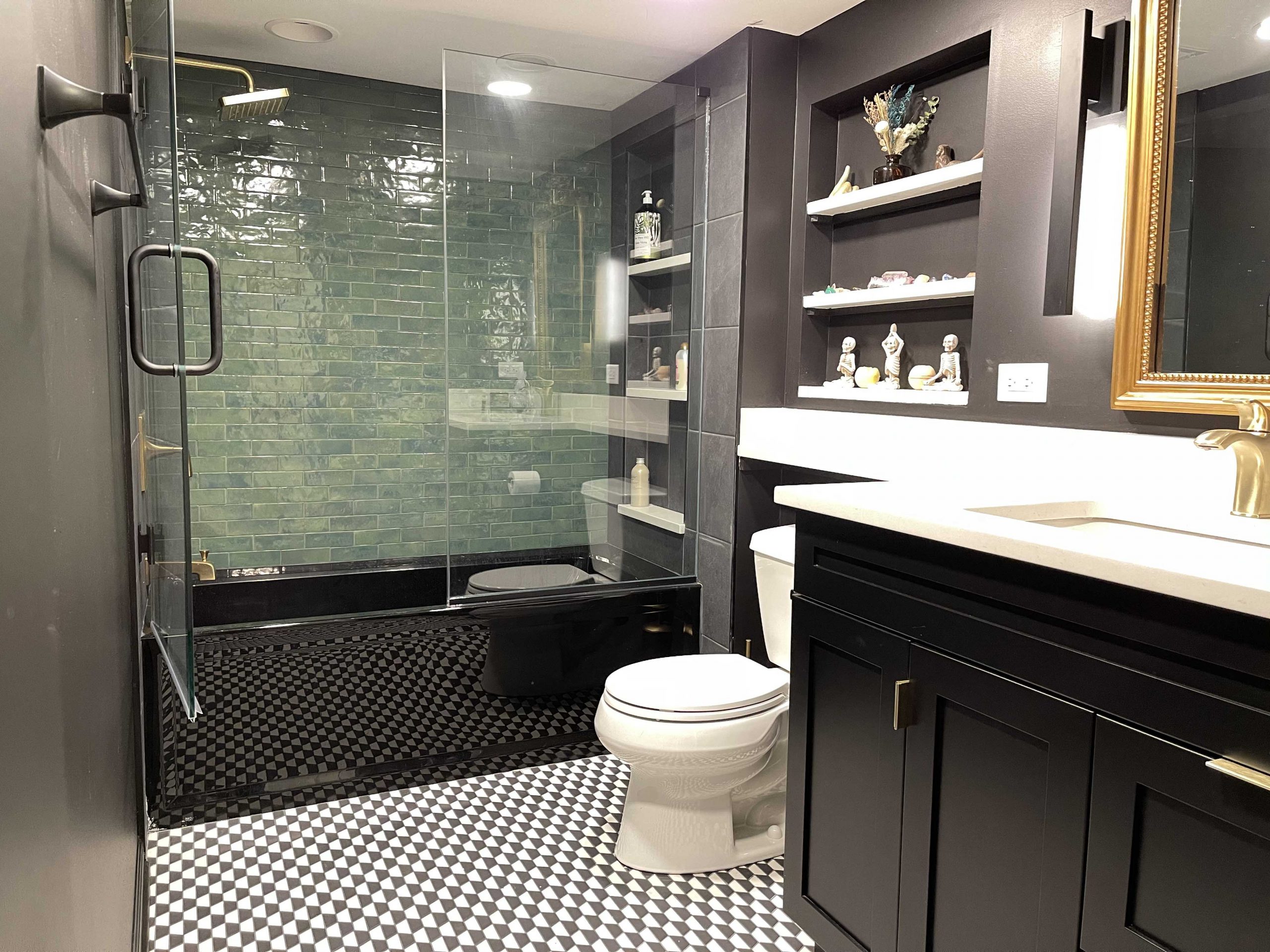 Bathroom with black tub and vanity cabinets and an emerald green shower wall