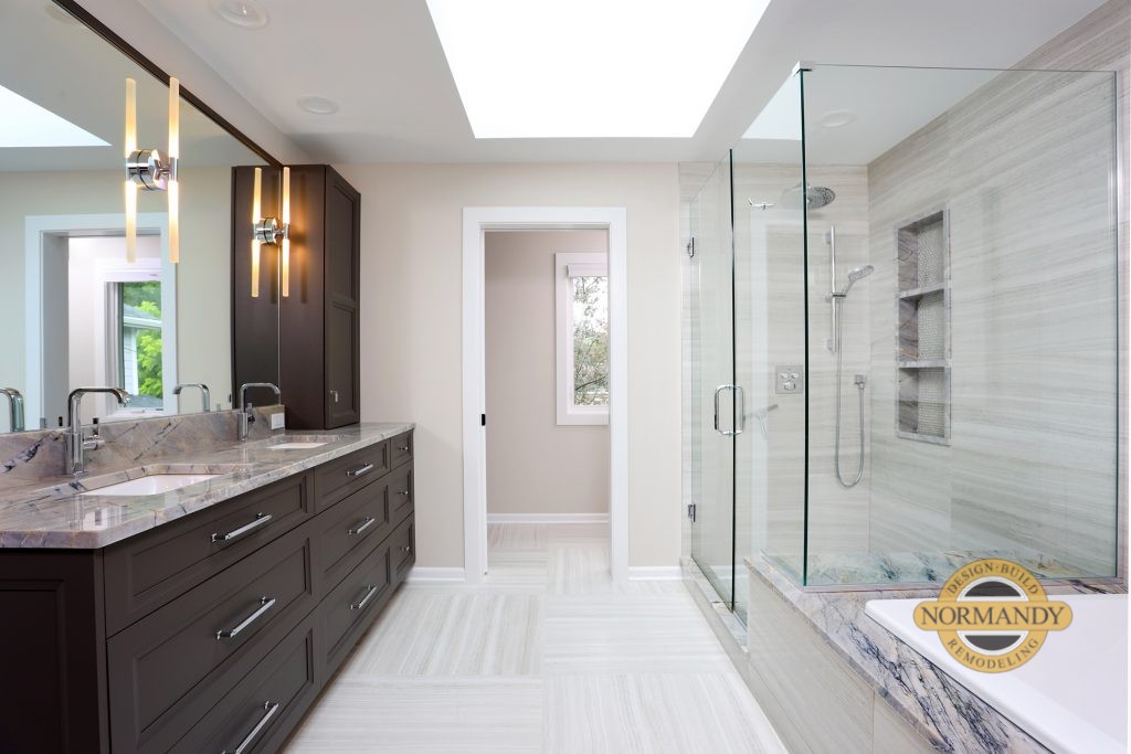 Bathroom with stained vanity, glass shower enclosure, and bathtub