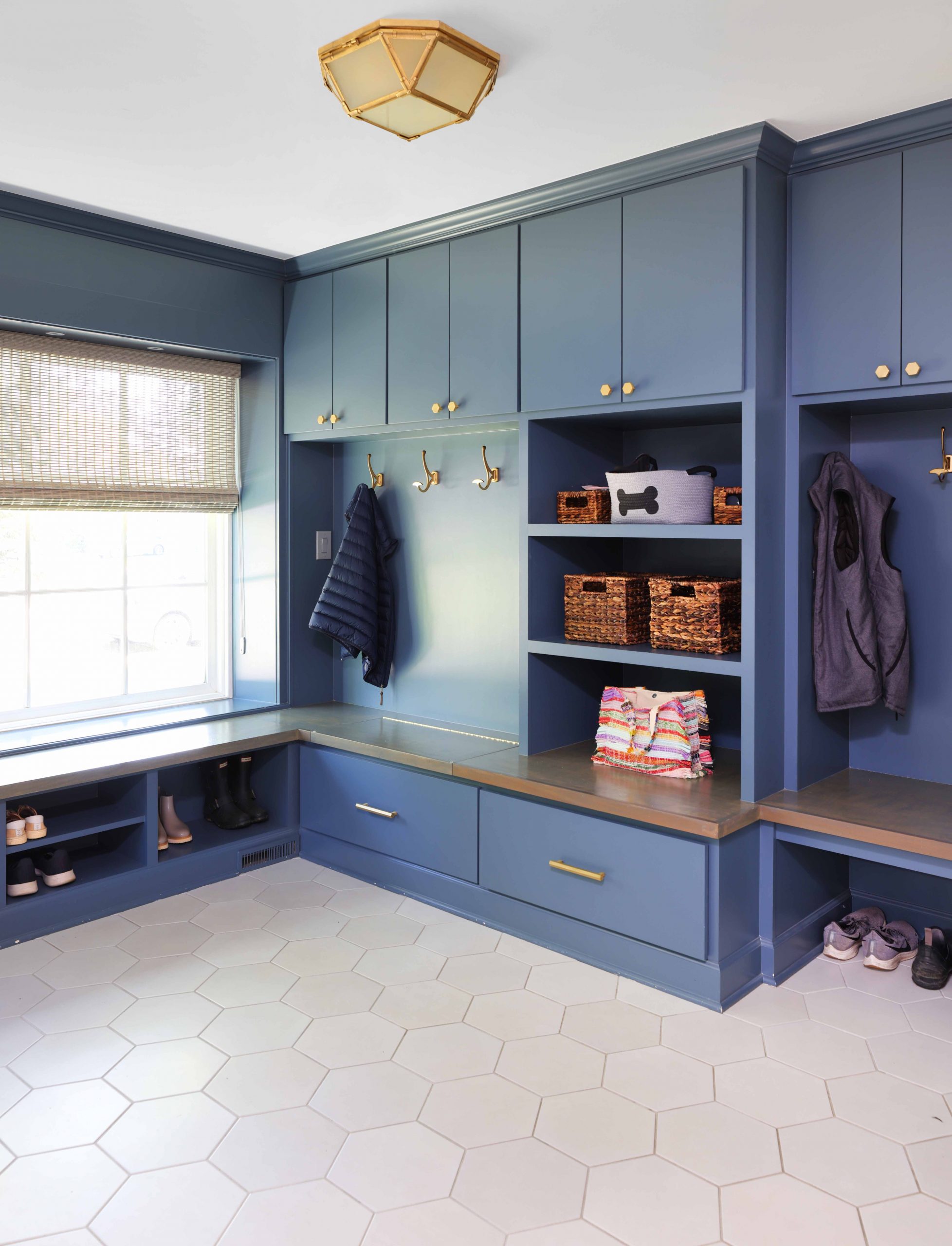 blue painted mudroom with hooks, shelves, cabinets and cubbies