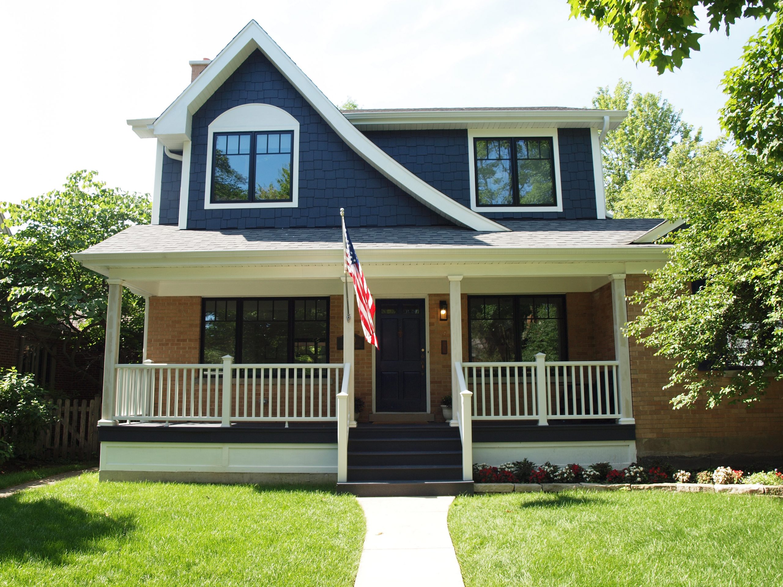 exterior of home blue siding on second level brick on lower with asymmetrical roofline