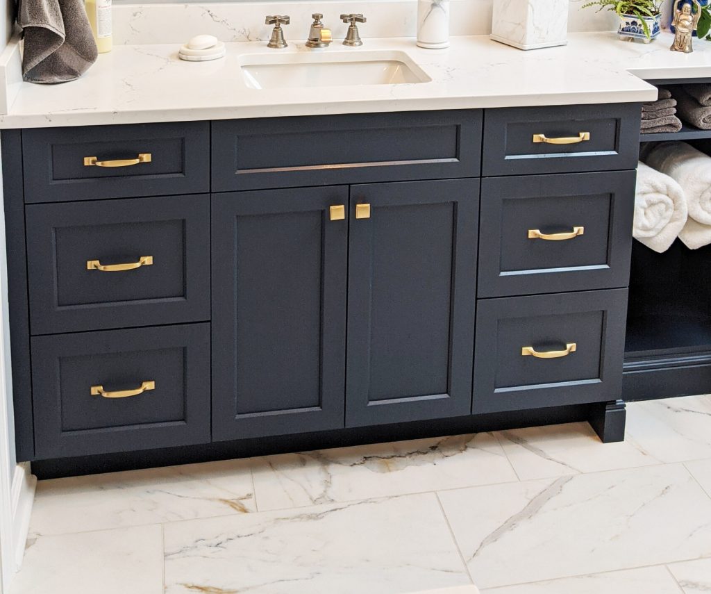 Bathroom floor tiles in a 1/3 offset pattern, blue vanity with gold fixtures