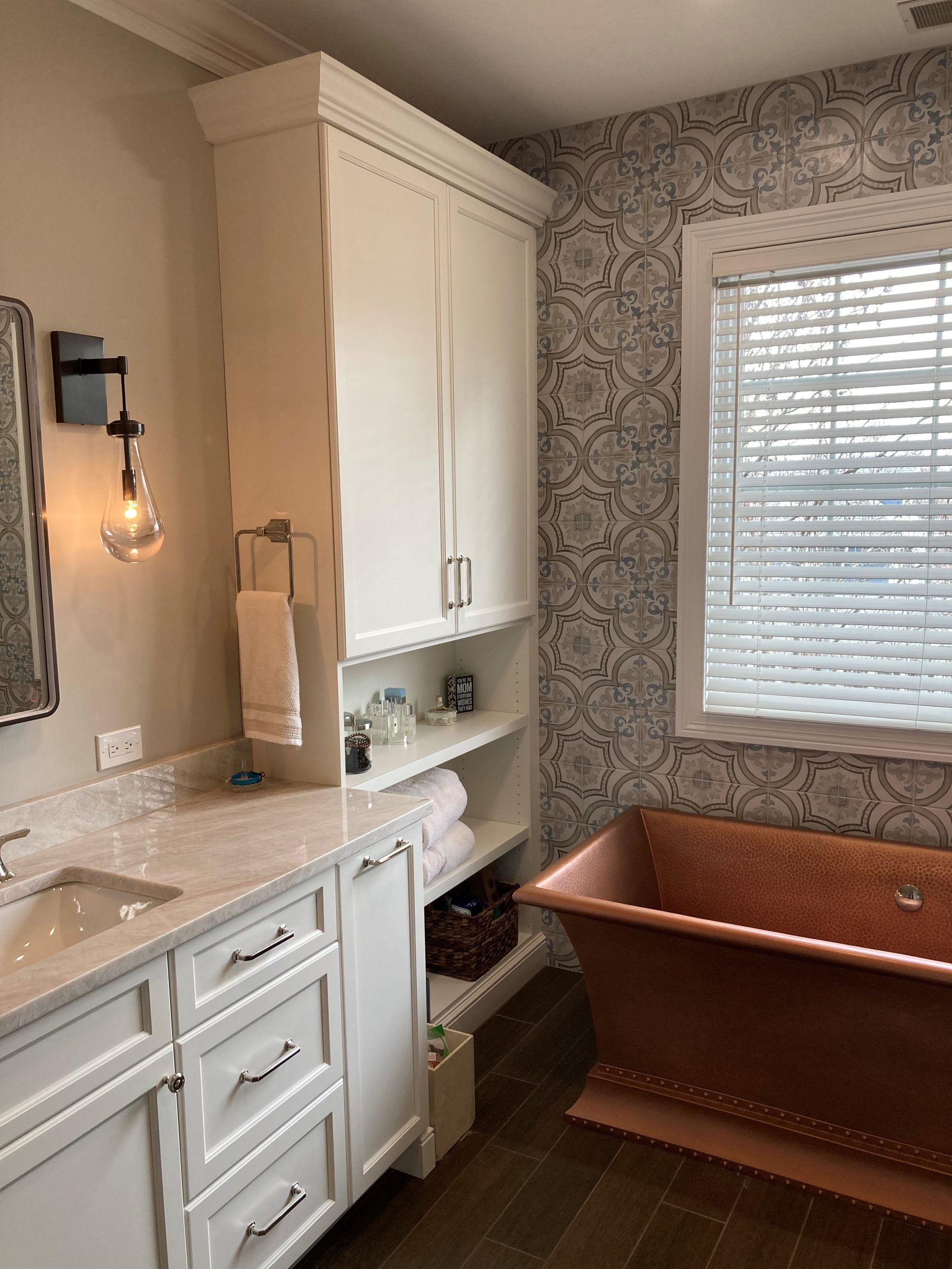 copper tub, white cabinetry, light counters, dark floor