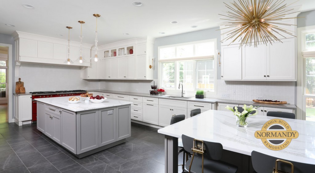 Two islands and a bright red stove add personality to this white kitchen